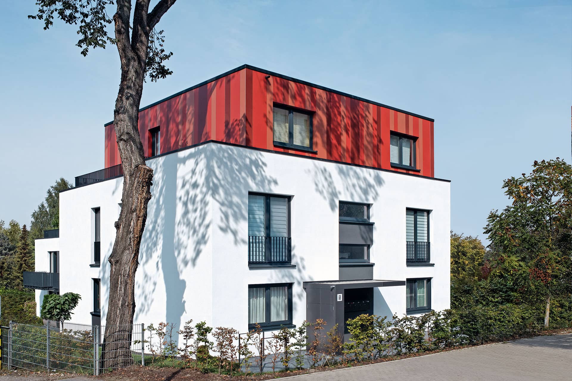 Mehrfamilienhaus mit weißer Fassade und Schüco Corona CT 70 Kunststofffenstern